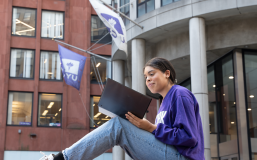 A student poses on Gould Plaza